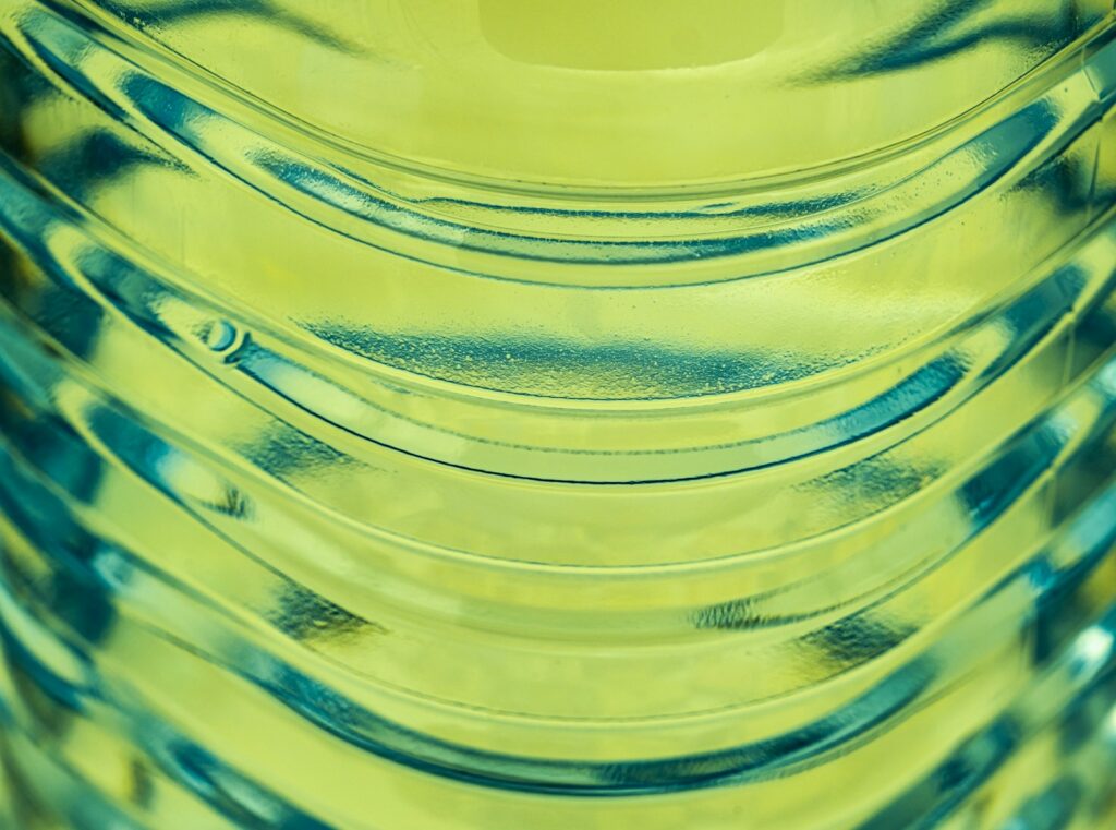 a close up of a yellow vase filled with water